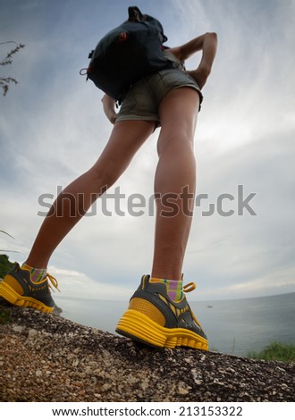 Lady hiker standing on the rocky ground. Focus on the boot