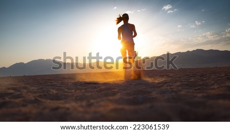 Young lady running in the desert at sunset Young lady running in the desert at sunset