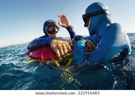 Free diver showing ok signal after deep dive to his safety buddy