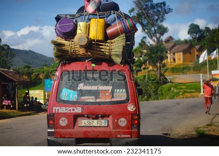 MADAGASCAR- DECEMBER 23, 2013. Overloaded bus moves on the asphalt road through the african village