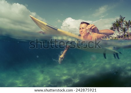 Young lady paddling on the surf board