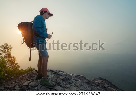 Hiker standing on top of the mountain with backpack