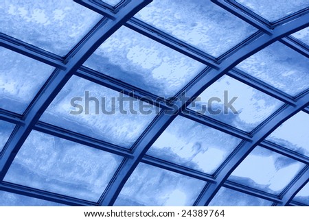 Transparent blue toned glass roof with snow