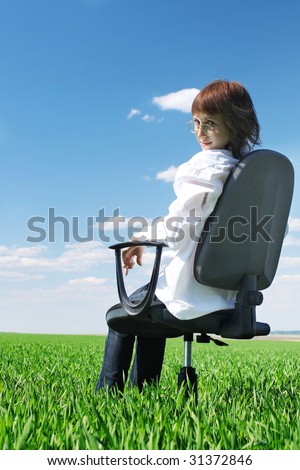 Woman on chair in green field