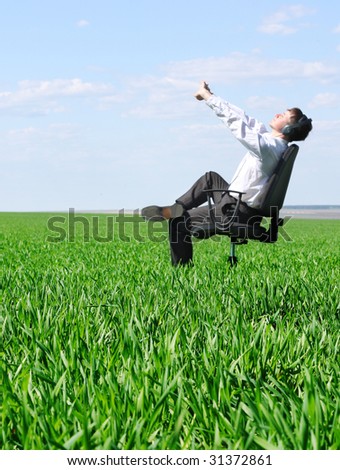 Stretching man on chair in green field