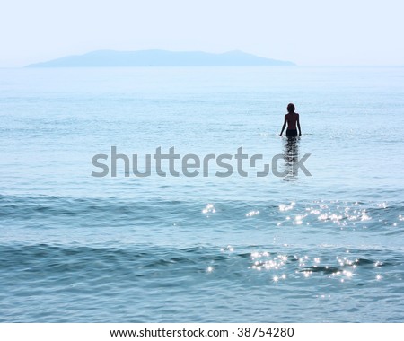 Alone woman standing in blue sea