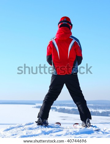 Skier standing on top of a hill before riding