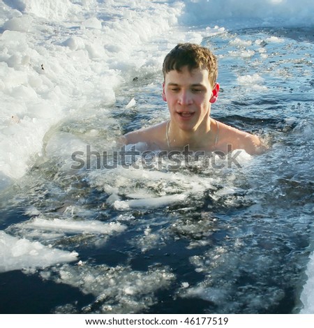 Young man swimming in cold water