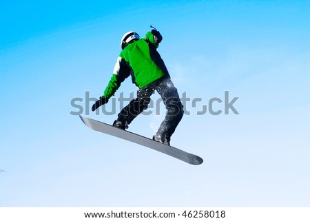 Snowboarder in jump over blue clear sky