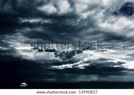 Alone white little boat on sea and dark storm clouds