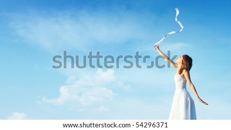 Young woman in white dress with white ribbon over blue cloudy sky background