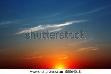 Blue sunset sky with sun and white clouds