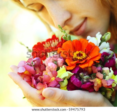 Young woman with flowers over natural background