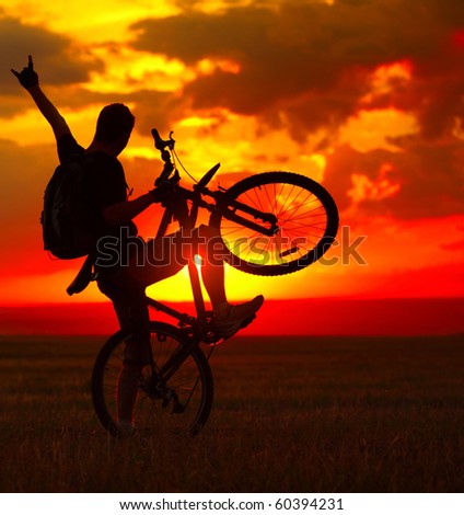 Silhouette of a man with bike on red sunset