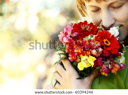 Young smiling woman with closed eyes and flowers bouquet
