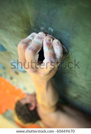 Young man climbing on indoor wall