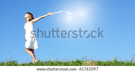 Woman in white dress and ribbon in hand on blue clear sky