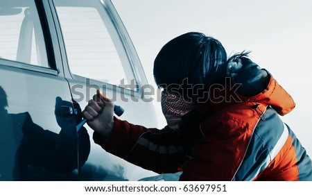 Young man breaking door of a car