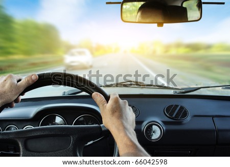 stock photo Driver's hands on steering wheel inside of a car