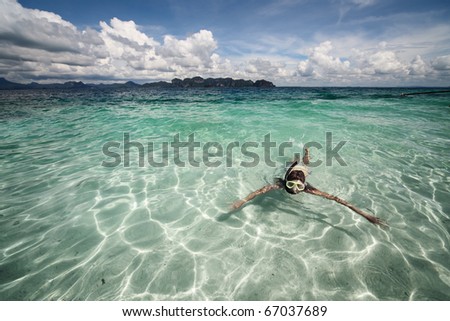 Young woman swimming with mask in clear sea