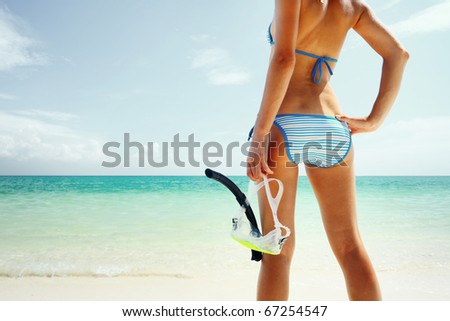 Young woman with a mask going to snorkel in clear sea