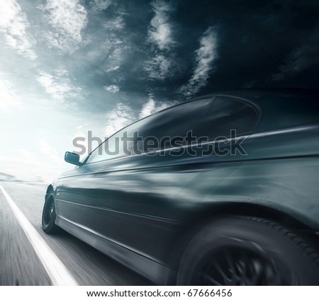 Blurred car on asphalt road and sky with clouds