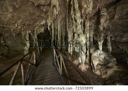Wooden bridge into dark cave
