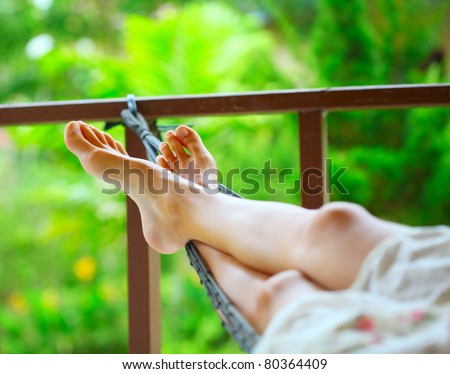 stock photo Feet of a young woman lying in hammock in a garden