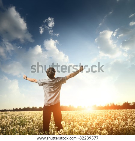 stock-photo-young-man-standing-on-a-meadow-with-raised-hands-and-looking-to-a-sky-82239577.jpg