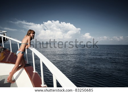 Young woman standing on a ship\'s board and looking to a horizon