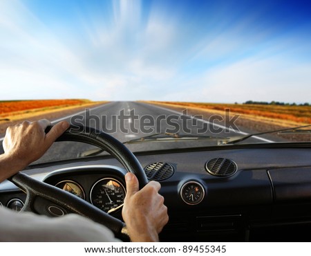 Driver\'s hands on a steering wheel