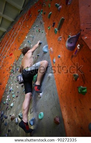 Young man climbing indoor wall