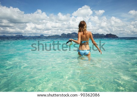 Young woman going to swim with mask in clear tropical sea
