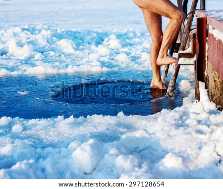 Man is going to swim in the ice hole at sunny day
