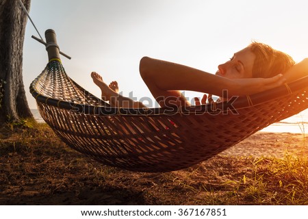 Lady relaxing in the hammock on the beach