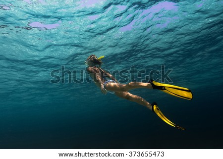 Lady swimming underwater in a tropical sea