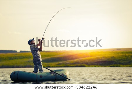 Mature man fishing on the lake from inflatable boat