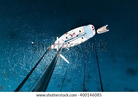 Aerial view of the sailboat anchored in the tropical calm sea