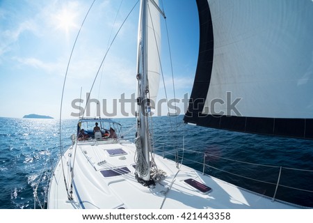 Young friends sailing in a blue sea on the yacht
