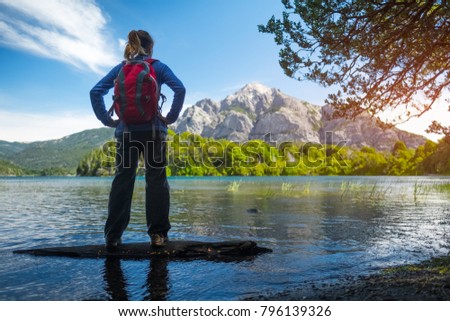 Woman hiker enjoys view of the lake and mountains. Bariloche, Argentina