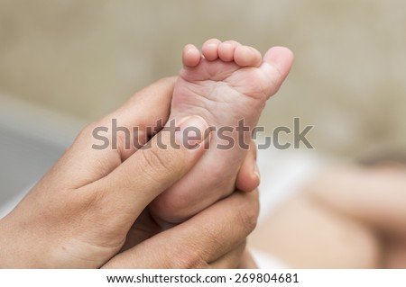 Mom checks reflex baby child moving her fingers on foot