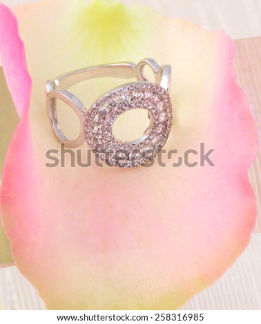 White gold Diamond ring on a pink and yellow rose petal