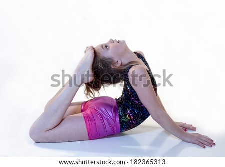 Girl doing gymnastic moves  while raising feet to her head