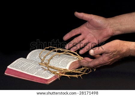 Open worn hands to the Bible and crown of thorns