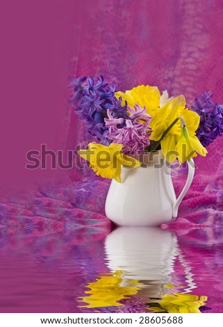 Print of small vase with flowers and fabric surrounding it with its reflection in the water