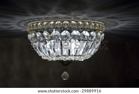 Night time view of crystal ceiling light fixture with its reflections overhead