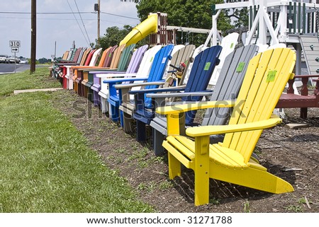 Wooden high-back lawn chairs being sold on roadside.