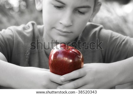 Black and white photo of young boy admiring the red apple about to eat
