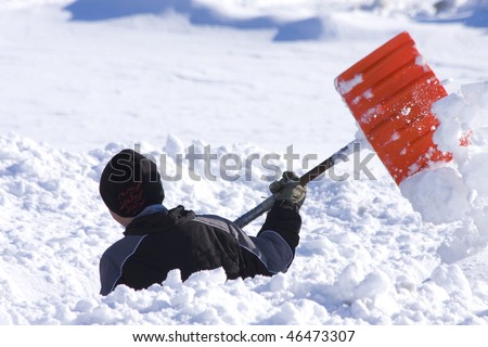 Boy shoveling deep snow