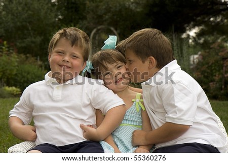 Brothers and their sister enjoying each other\'s company outdoors